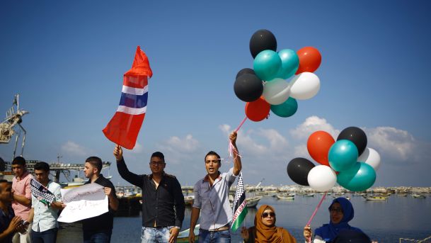 people waving flags and coloured balloons