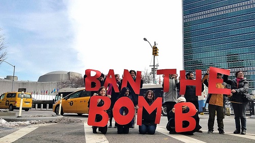 a group holding up red letters 'Ban the Bomb' with yellow taxis in the background