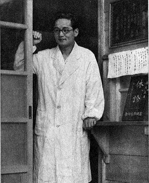 Man in a doorway wearing a white coat