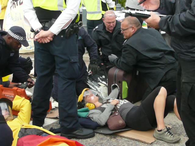 Another protester chained to another lying in the road