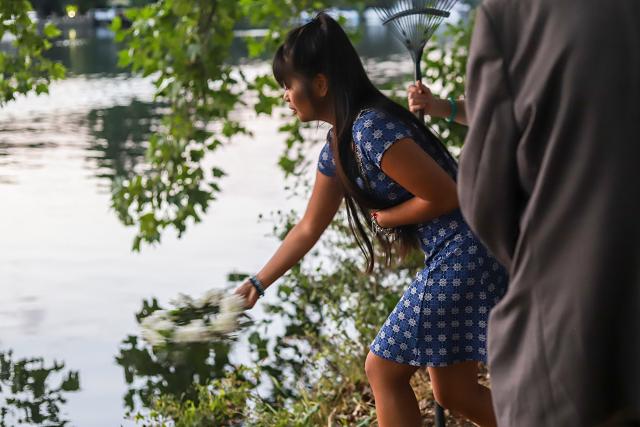throwing white flowers onto the river