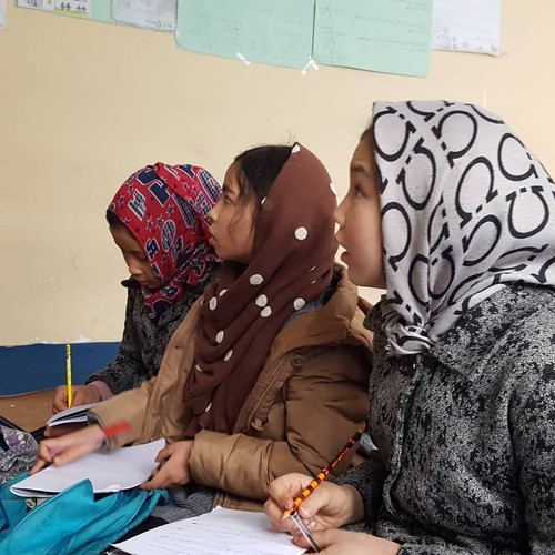 three girls with headscarves studying