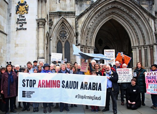 a group of protestors outside the Royal Courts of Justice with a banner reading 'Stop Arming Saudi Arabia'