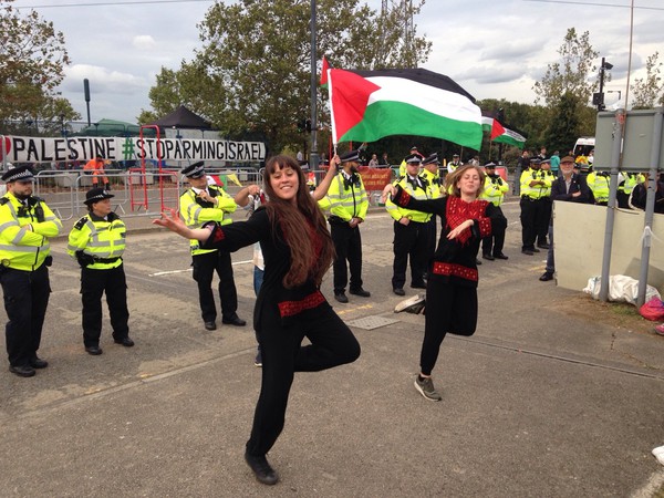 dancers with Palestinian flag while policemen look on
