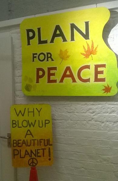 hand-painted placards: 'Plan for Peace' and 'Why blow up a beautiful planet!'