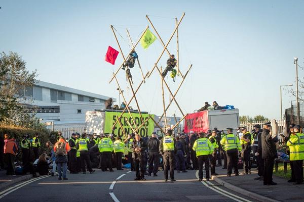 a group of protestors, some on precarious structures, and police