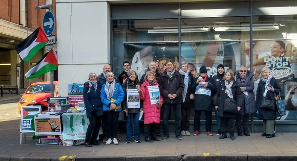 group of 14 protestors outside a shop window